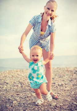 happy family on nature mother and baby doing first steps