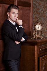 attractive young businessman in a suit in vintage interior