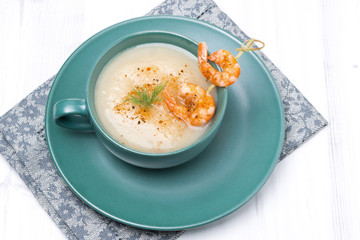 potato cream soup with shrimps on a skewer, top view