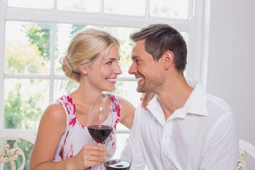Happy loving couple with wine glasses looking at each other