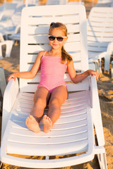 Adorable kid sunbathing on a beach