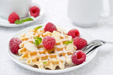 waffles with fresh raspberries, almonds and mint on a plate