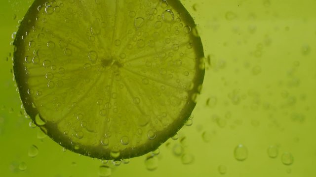 lime in soda water on green background