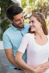 Fototapeta premium Loving man embracing woman from behind outdoors