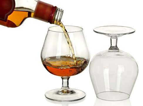 Bottle of brandy, a jet, and two wine glass isolated on a white