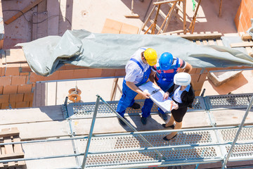 Team bespricht Bau Pläne auf einer Baustelle