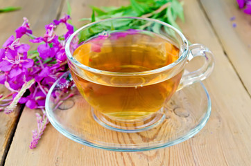 Herbal tea in glass cup of fireweed on board
