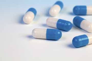 Colorful medical capsules on blue background.