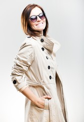 Smiling fashionable woman in coat with sunglasses