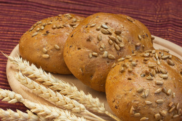 Wholemeal bread with wheat ears on the table.