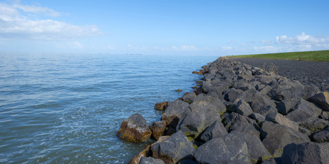 Dike with a stony shore along a lake in spring