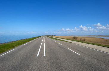 Fototapeta premium Road on a dike along a lake in spring