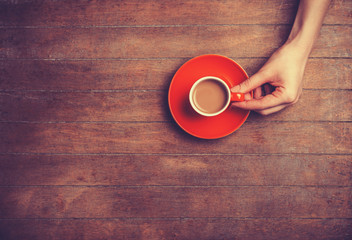 Female hand holding cup of coffee.