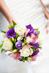 Wedding bouquet with different flowers in hands of bride
