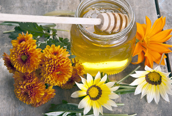jar of honey with different flowers