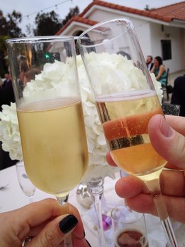 Two people toast their sparkling wine at a celebration.