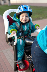 Naklejka premium Little boy in the seat bicycle behind mother