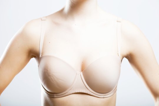 Skin-colored bra, breast of young woman
