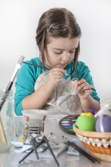Fototapeta na wymiar Cute little girl painting easter eggs