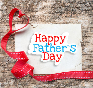 Happy father day on aged paper on wooden background with ribbon 