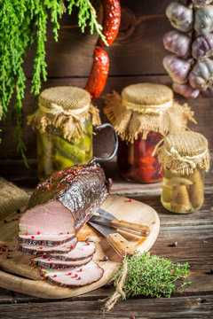 Rural smokehouse with ham and herbs