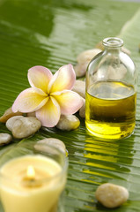 Obraz na płótnie Canvas massage oil and frangipani,candle and banana leaf