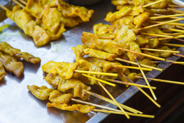 Satay chicken on grill.