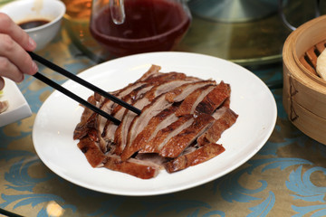 Person takes slice of peking duck