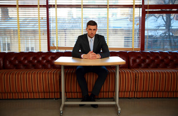 Confident businessman sitting at the table in office