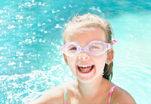 Pretty smiling little girl in swimming pool