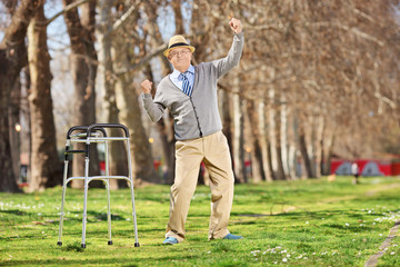 Old man with walker gesturing happiness outdoors