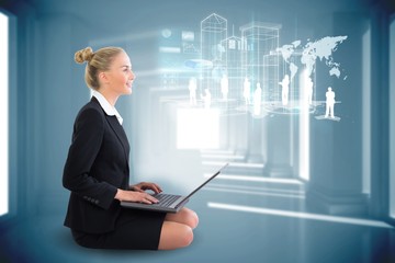 Blonde businesswoman sitting using laptop with interface