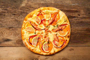 Salmone pizza on wooden table.