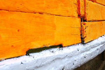 A close up veiw of the paint on a wooden boat.
