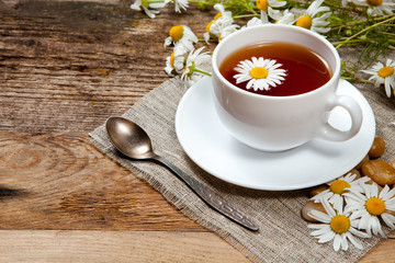herbal tea with chamomile on old wooden table