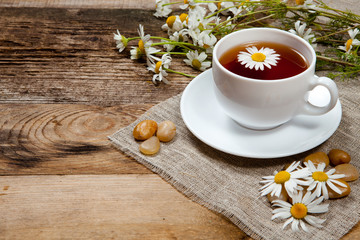 herbal tea with chamomile on old wooden table