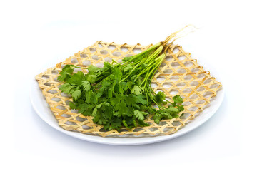 Coriander Coriandrum sativum on wickerwork dish white background