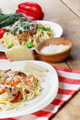 Pasta with shrimps and mashrooms on the wooden table
