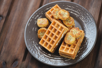 Waffles with grilled banana, dark wooden background