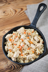 Pilaf with chicken in a cast-iron pan, high angle view