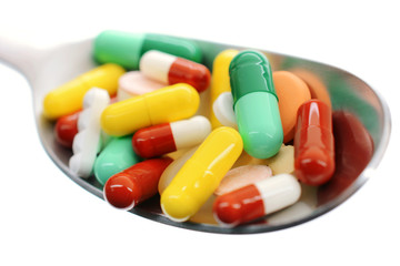 Bunte Tabletten und Pillen auf Löffel
