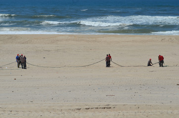 Fischer beim Netzeinholen am Strand von Mira