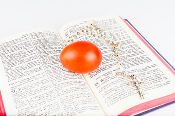 Easter egg with rosary on a holy Bible