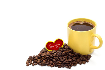 Yellow cup of coffee with coffee beans and small red heart