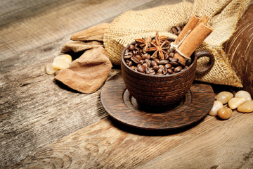 Wooden cup with coffee-beans on wooden table