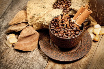 Fototapeta na wymiar Wooden cup with coffee-beans on wooden table