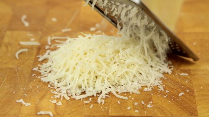 Grating parmesan cheese on a chopping board.