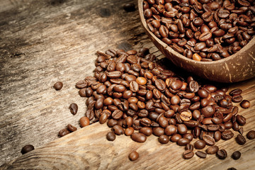 Wooden cup with coffee-beans on wooden table