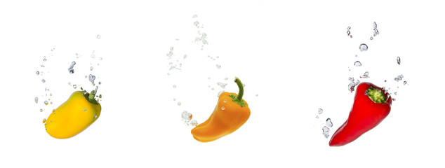 Gelbe, orangene und rote Paprika im Wasser mit Luftblasen