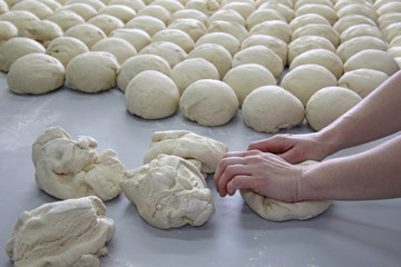 Female baker kneading dough in a bakery